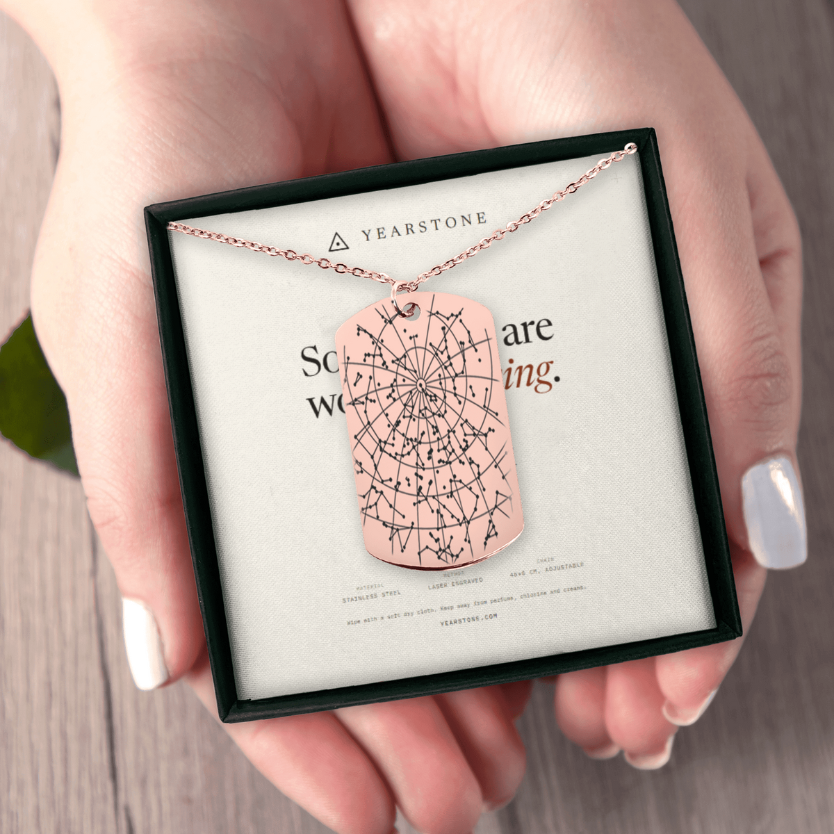 Hands holding the gift box with a rose gold plated star map tag necklace
