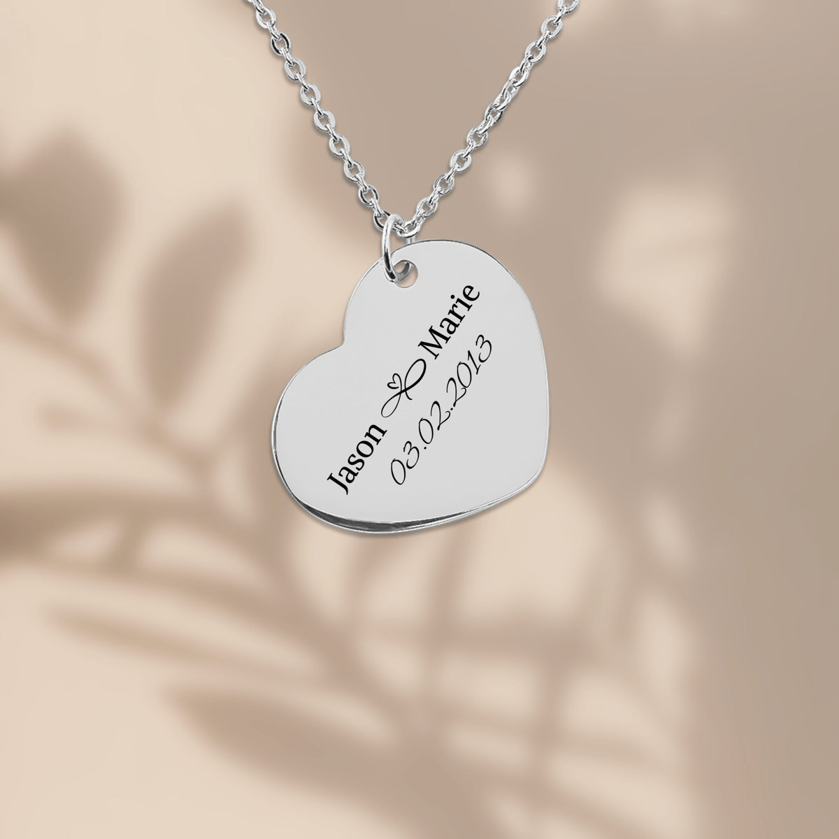 Stainless steel heart pendant engraved with two names and a date