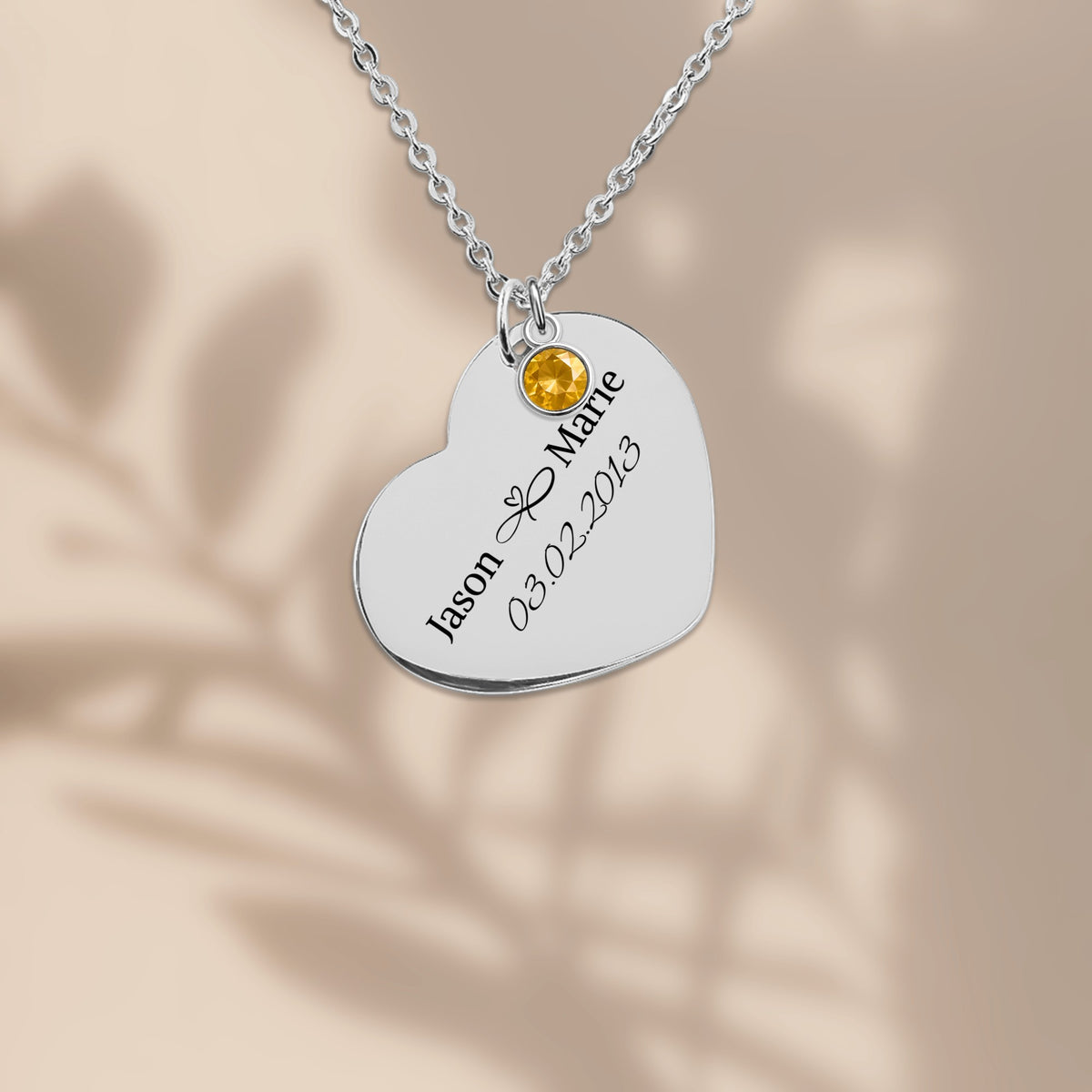 Stainless steel heart pendant engraved with two names and a date
