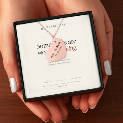 Hands holding the gift box with a rose gold plated engraved heart necklace